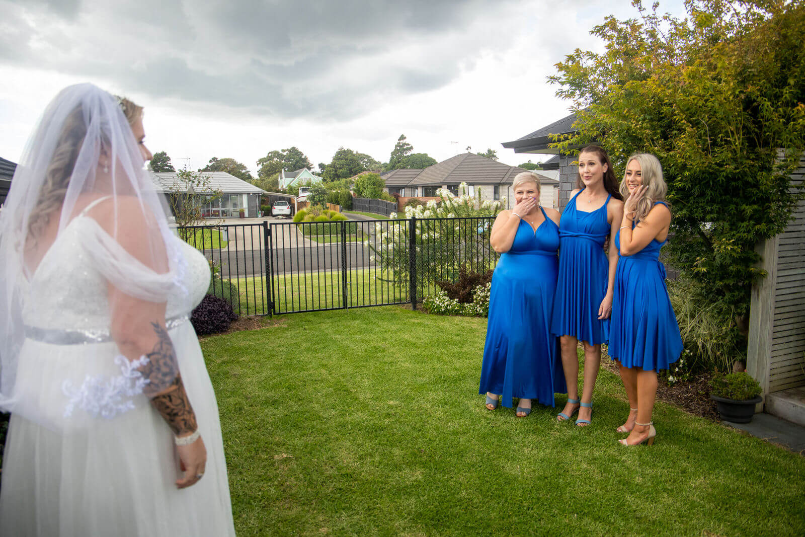 Auckland wedding photographer — emotional first look moment with bridesmaids in blue