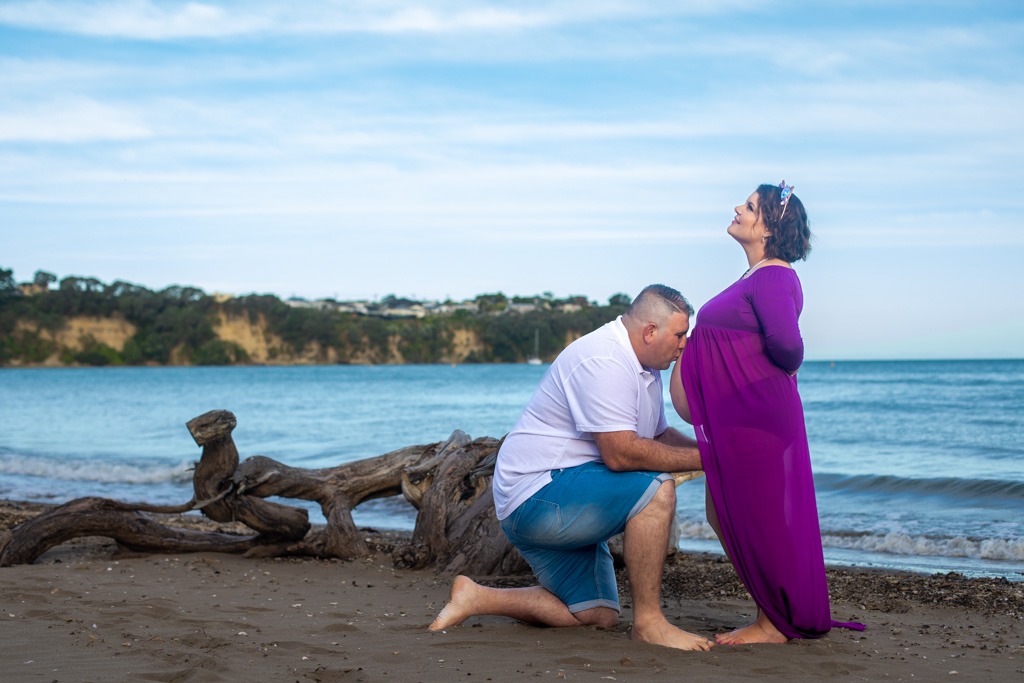 Auckland maternity photographer — beach driftwood portrait at dusk
