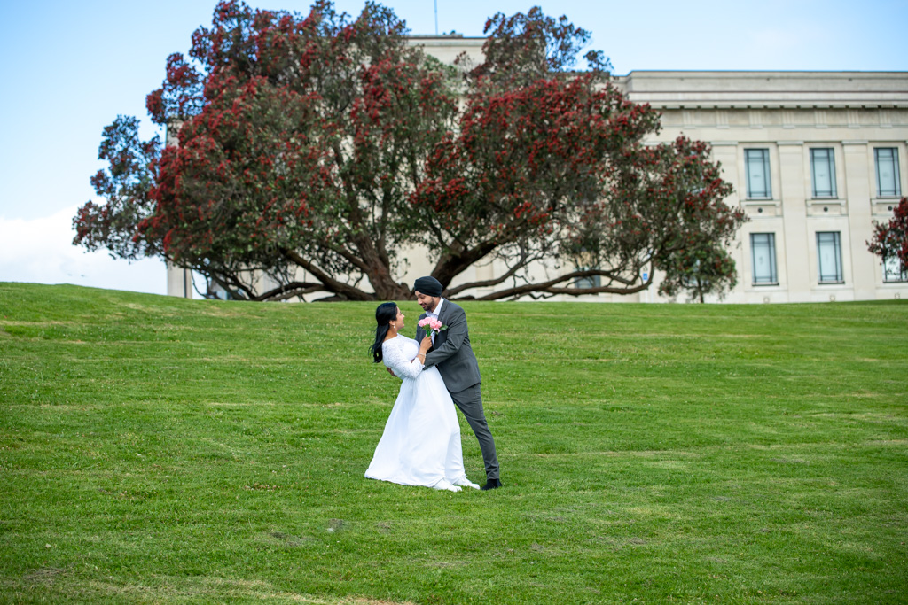 Auckland wedding photographer — couple at Auckland Museum with pohutukawa tree