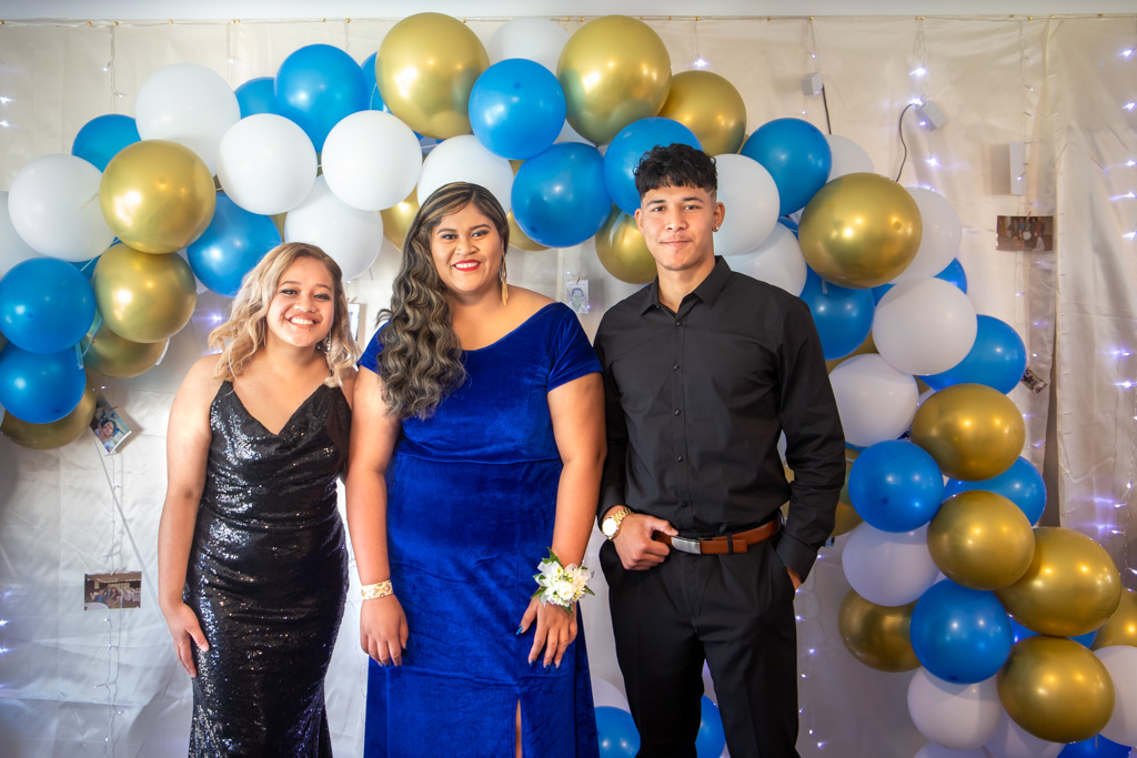 Auckland events photographer — group at formal celebration with balloon arch