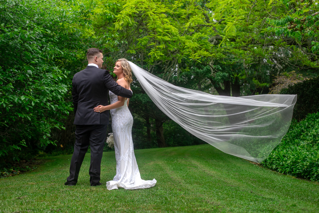 Auckland wedding photographer — flowing veil in lush gardens